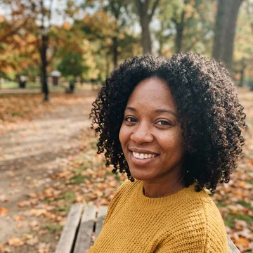 Starting photo: a smiling woman with curly hair